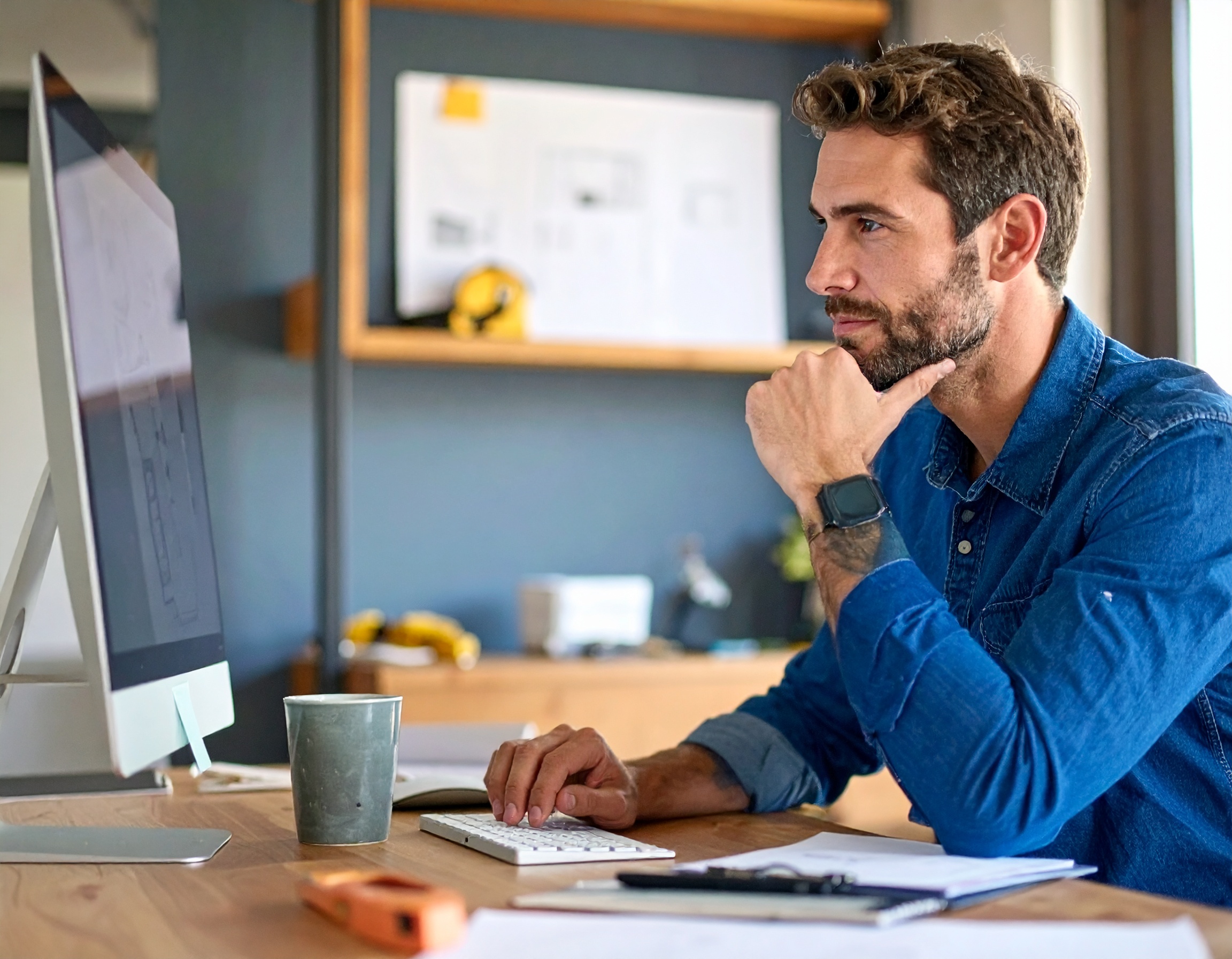 A homeowner reviewing property priorities at a desk.